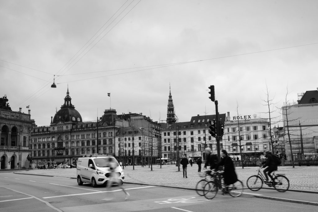 City in Motion Cyclists crossing a cobbled square in central Copenhagen, black and white street photograph