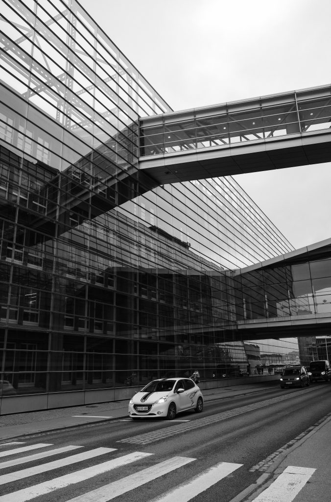 Glass and Skybridge, Copenhagen Glass facade and elevated skybridge over a Copenhagen street, black and white