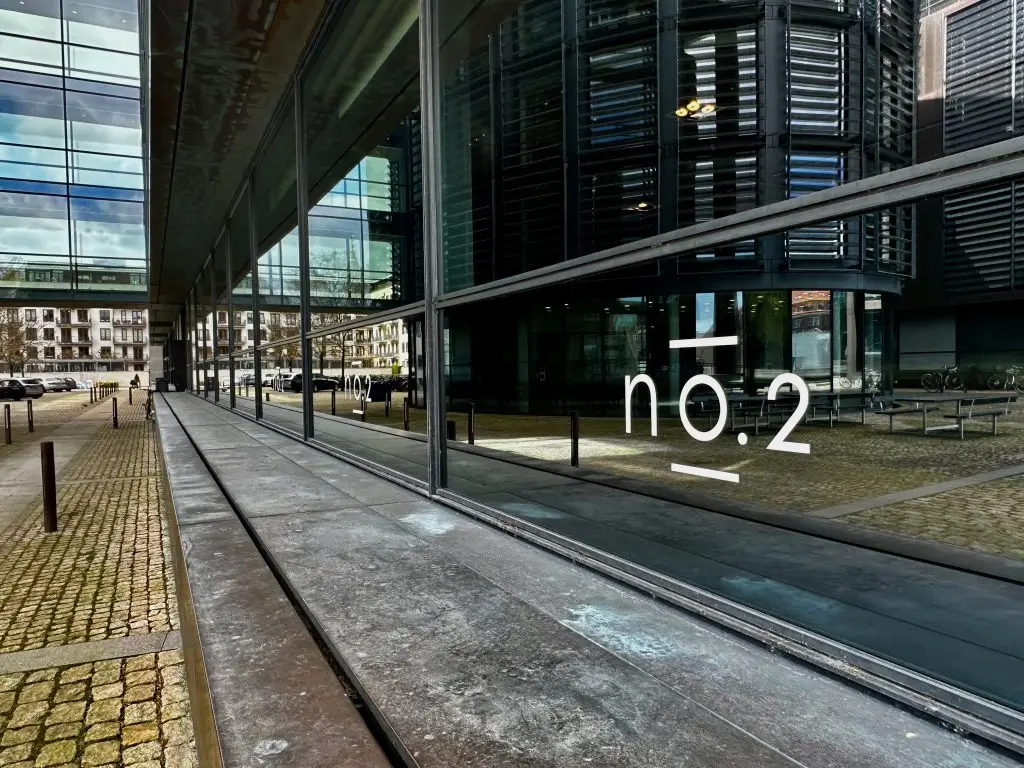 Reflections, Copenhagen Reflections in a dark glass facade beside a cobbled pavement, Copenhagen