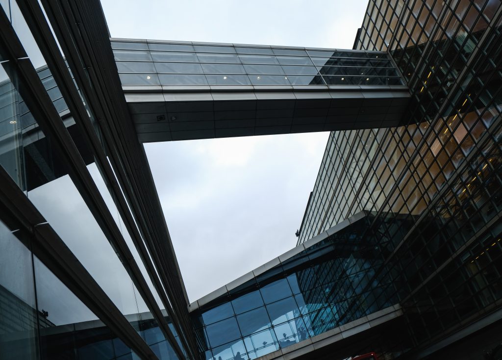 Skybridge, Copenhagen Glass skybridge between modern office buildings seen from below against a pale sky, Copenhagen