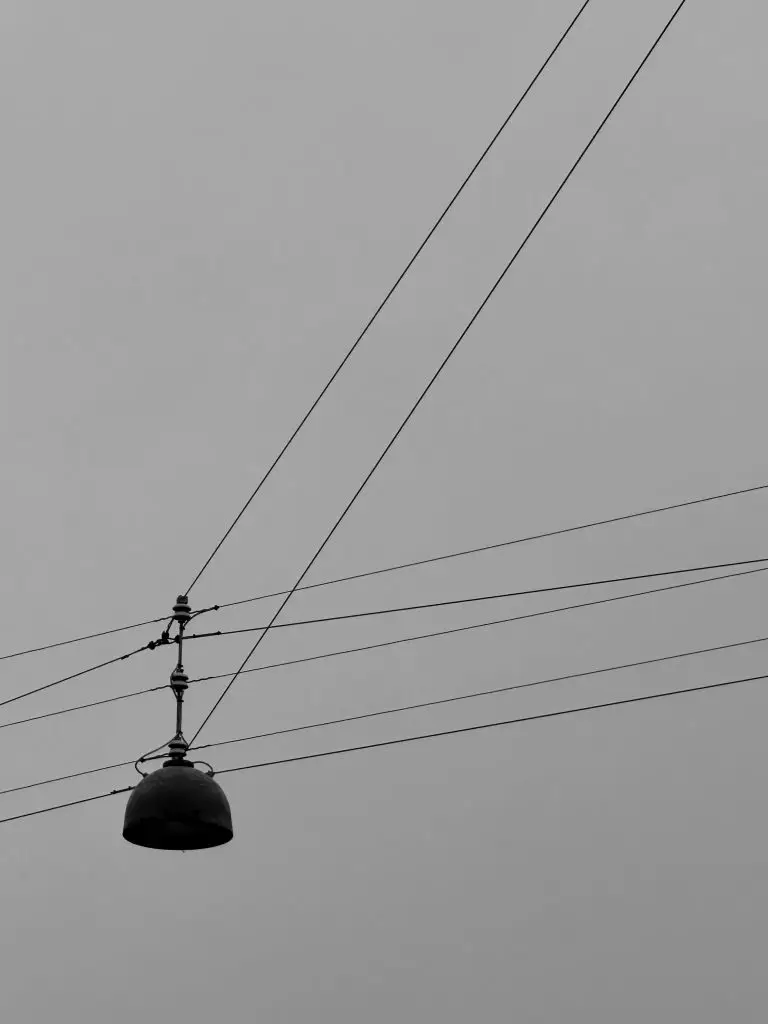 Hanging Street Lamp, Copenhagen Single street lamp hanging from cables against a grey sky, Copenhagen, black and white