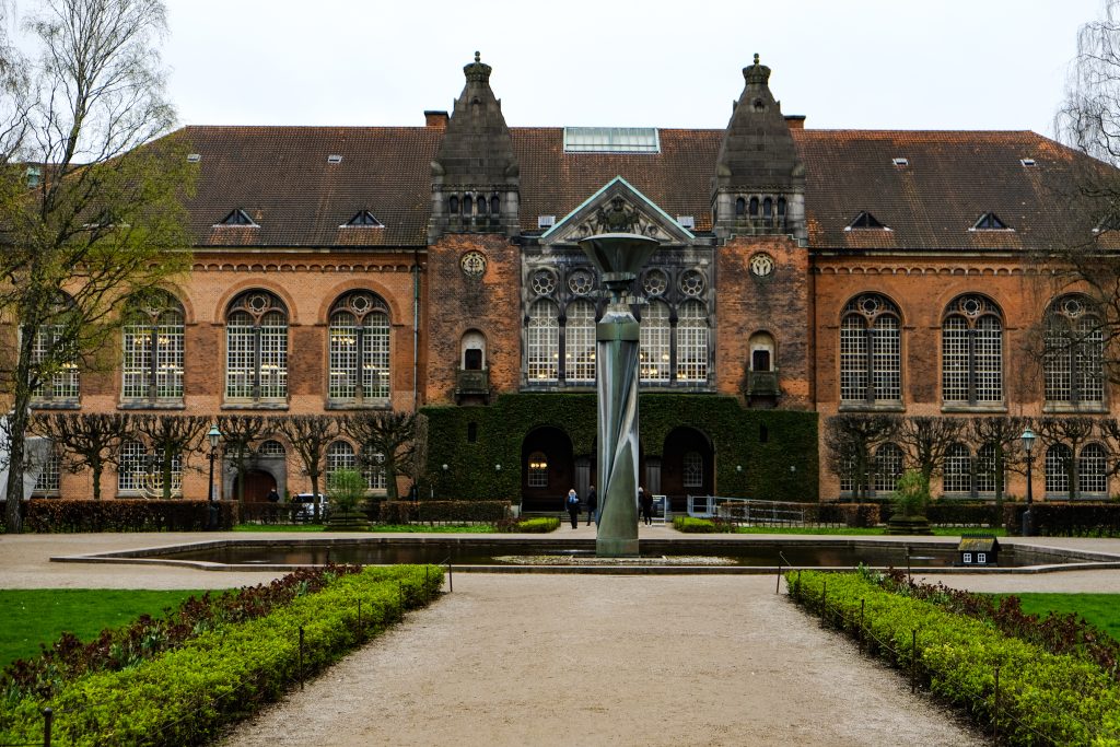 Red Brick and Garden, Copenhagen Historic red-brick building with a formal garden and a sculpture, Copenhagen