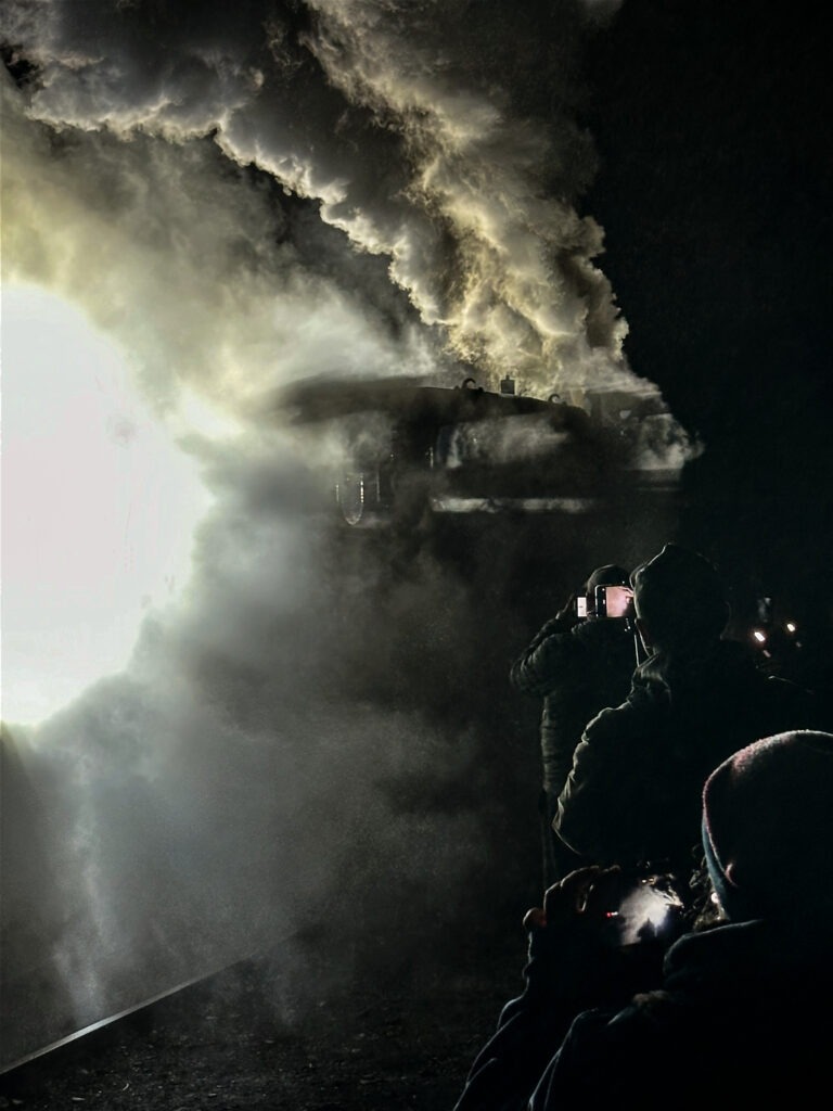 Into the Steam Narrow-gauge steam locomotive engulfed in steam at night with silhouetted onlookers, Bytom