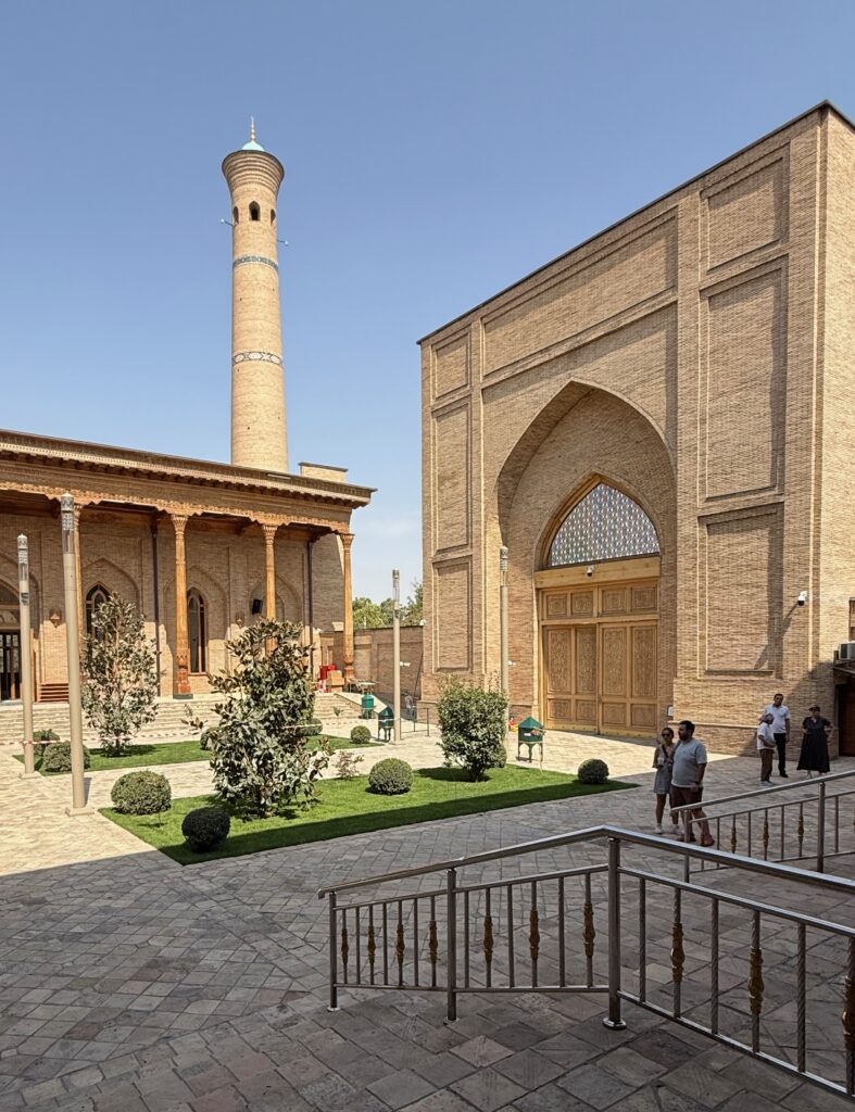 Tall minaret beside an ornate mosque facade in Tashkent