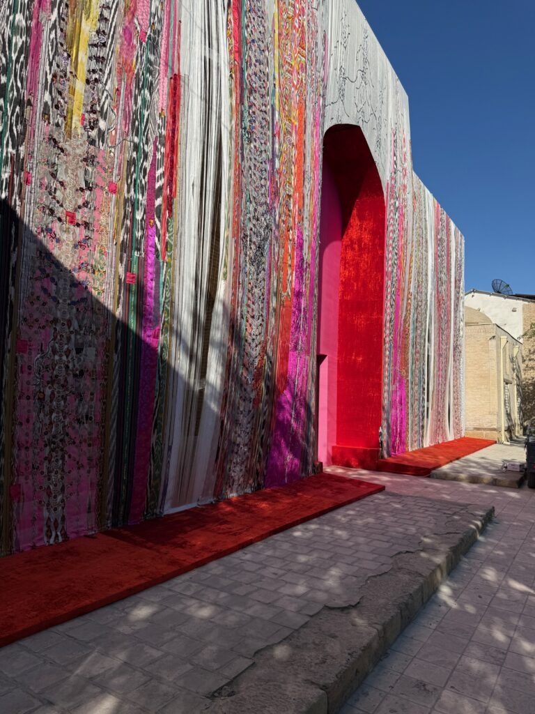 Red patterned textile hanging in a doorway, Bukhara, Uzbekistan