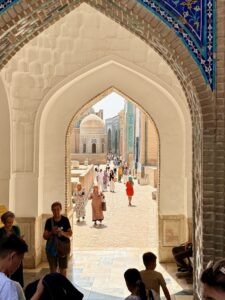 Visitors walking through a stone archway, Samarkand, Uzbekistan