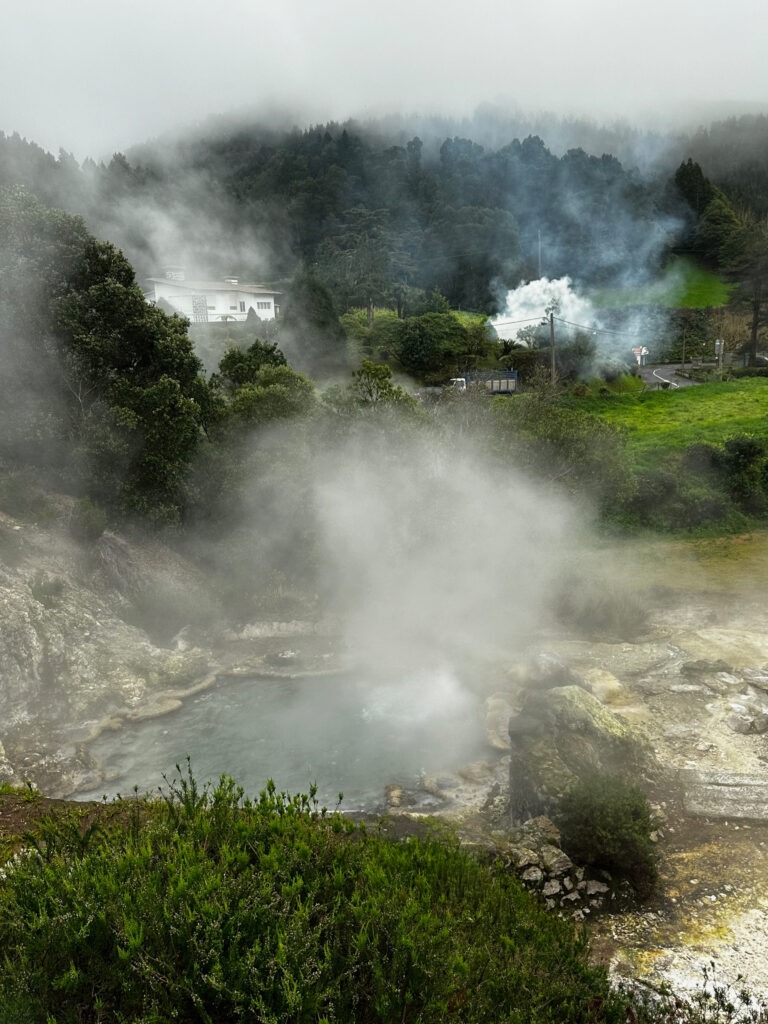Clouds of volcanic steam rising in a green valley, Furnas, Azores