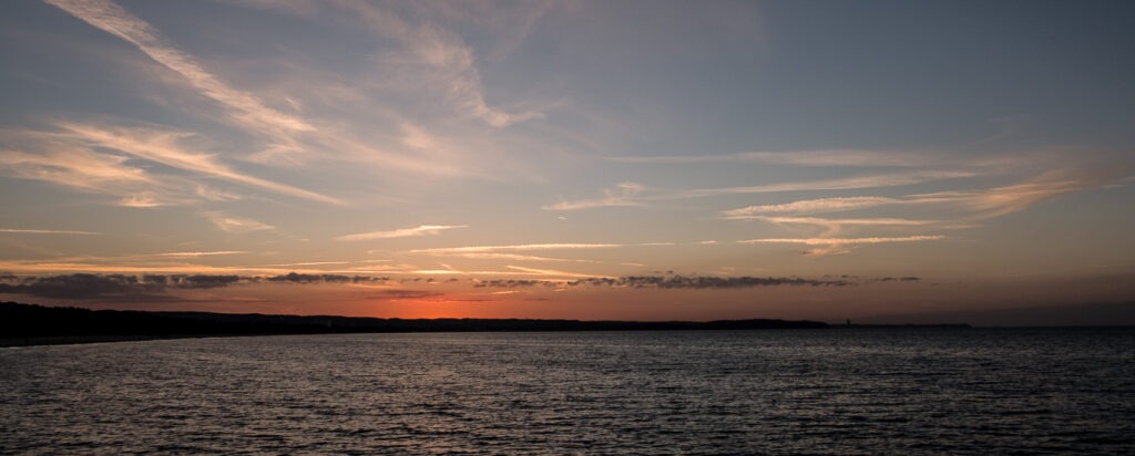 sunset over the Baltic Sea with dramatic clouds and calm horizon &ndash; fine art landscape photography