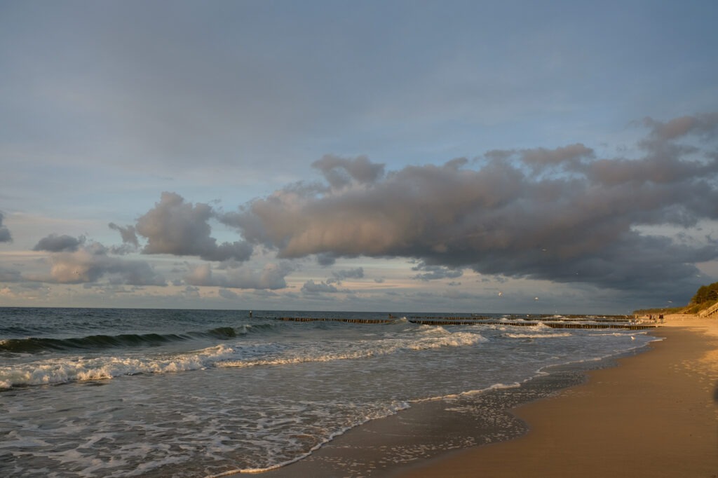 Gentle ocean waves and clouds lit by the last light of sunset, fine art coastal landscape