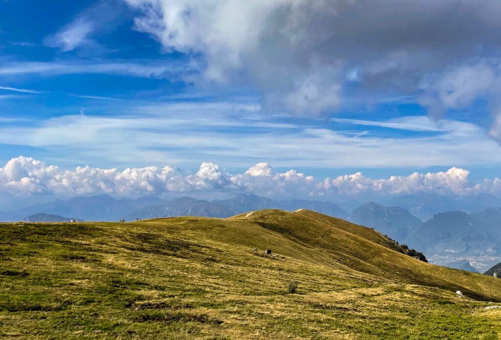 Rolling alpine meadows and distant mountain ridges under a wide blue sky, fine art mountain landscape